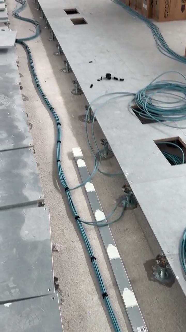 Raised access floor with underfloor busbar and data cables routed between pedestals