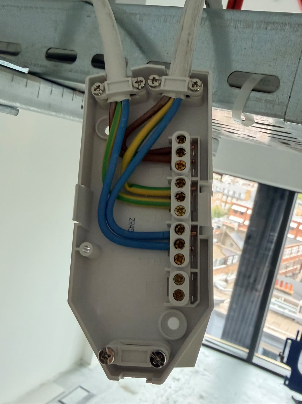 Open junction box under a cable tray with line, neutral and earth terminated